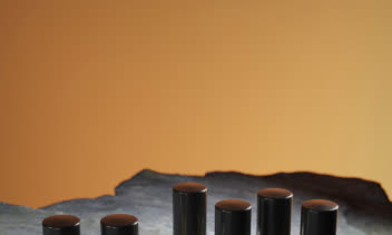 عکاسی تبلیغاتی و چیدمان هنری نمونه‌های عطر لوکس روی سطح سنگی