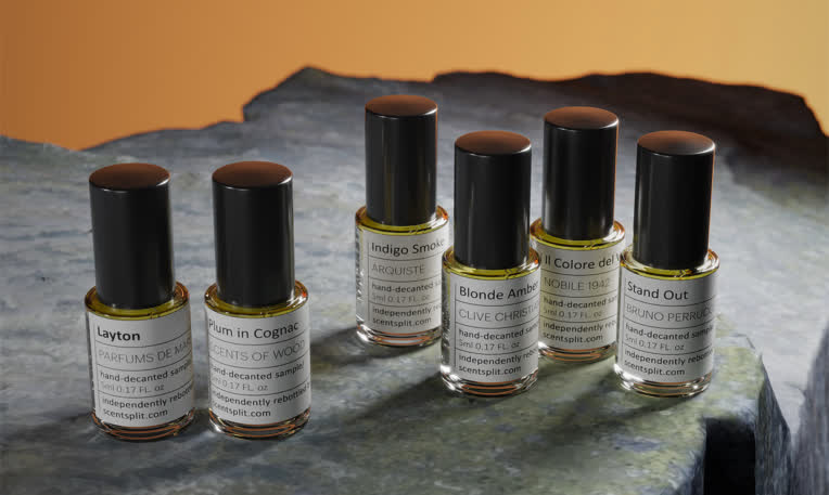 عکاسی تبلیغاتی و چیدمان هنری نمونه‌های عطر لوکس روی سطح سنگی